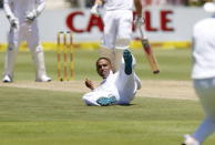 South Africa's Dane Piedt falls over while attempting to field from his own bowling during the second cricket test match against England in Cape Town, South Africa, January 2, 2016. REUTERS/Mike Hutchings