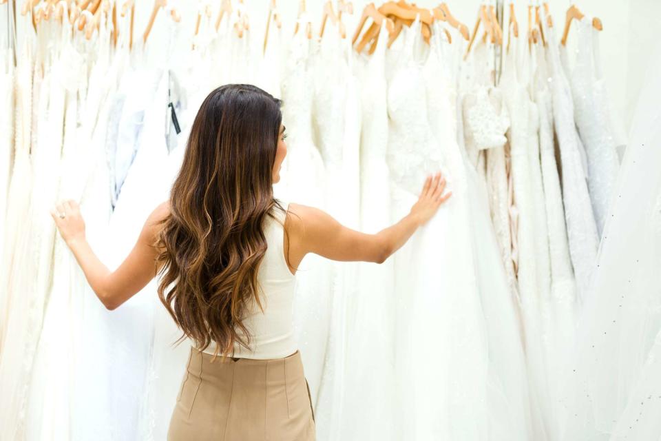 <p>Getty</p> Stock image of a bride looking at a rack of dresses 