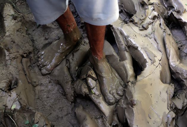 A man stand in mud after floodwaters hit his home, in Charsadda, Pakistan on Aug. 30, 2022. (Photo: Muhammad Sajjad/AP)