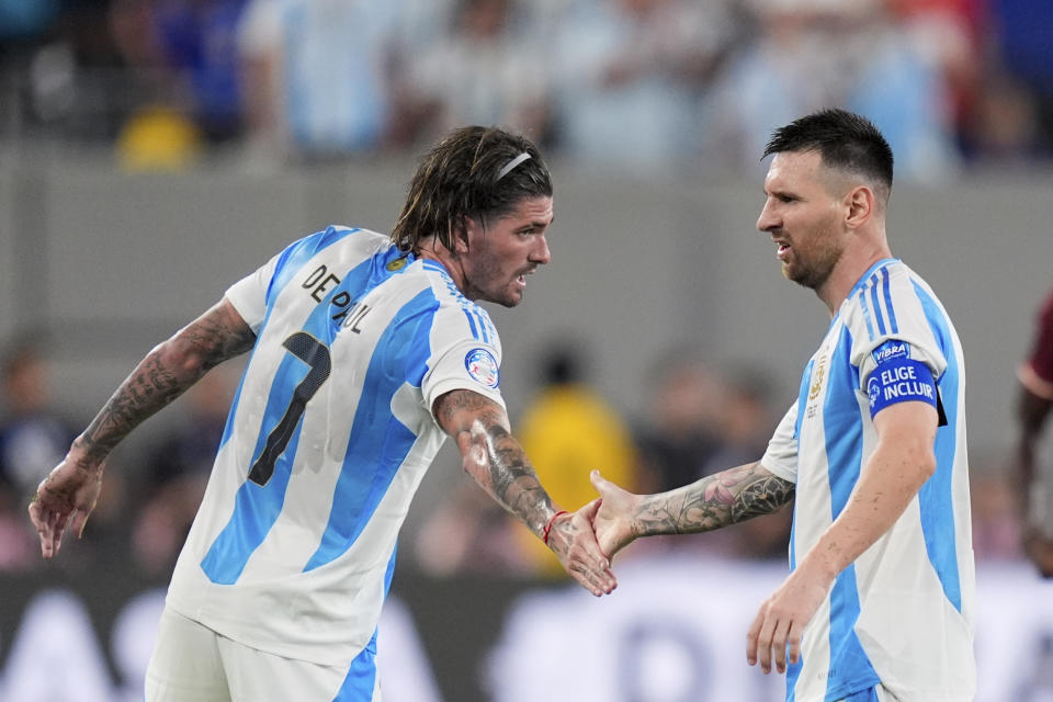 Argentina's Lionel Messi, right, high-fives Rodrigo De Paul during a Copa America semifinal soccer match against Canada in East Rutherford, N.J., Tuesday, July 9, 2024. (AP Photo/Julia Nikhinson)