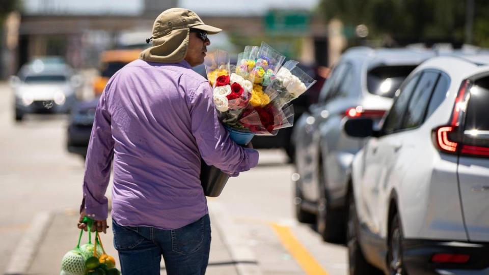 Street vendor Eddy Rivera is seen selling fruits and flowers near the intersection of Red Road and Northwest 135th St on Tuesday, May 2, 2023, in Miami Lakes, Fla. MATIAS J. OCNER/mocner@miamiherald.com