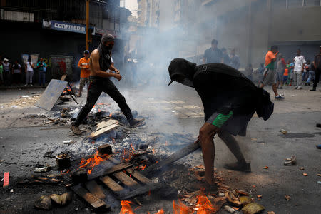 Demonstrators set up a fire barricade at a protest against the government of Venezuelan President Nicolas Maduro in Caracas, Venezuela March 31, 2019. REUTERS/Carlos Garcia Rawlins