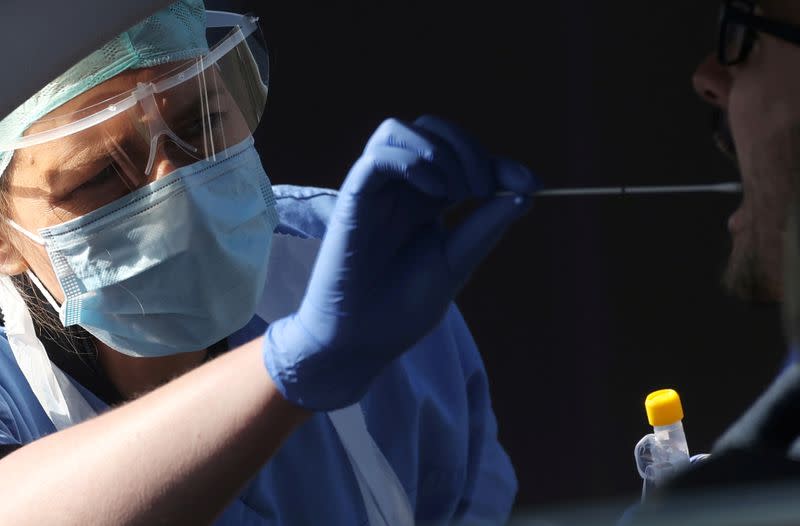 FILE PHOTO: A member of medical staff takes a swab from a person in a car at an NHS coronavirus disease (COVID-19) testing facility in Wolverhampton