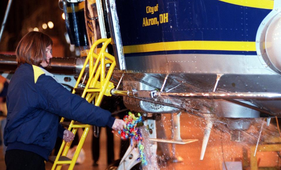 Former astronaut Sally Ride, the physicist who flew two space shuttle missions aboard the Challenger, breaks a bottle of champagne on the Spirit of Goodyear during ceremonies at Wingfoot Lake hangar in 2000.