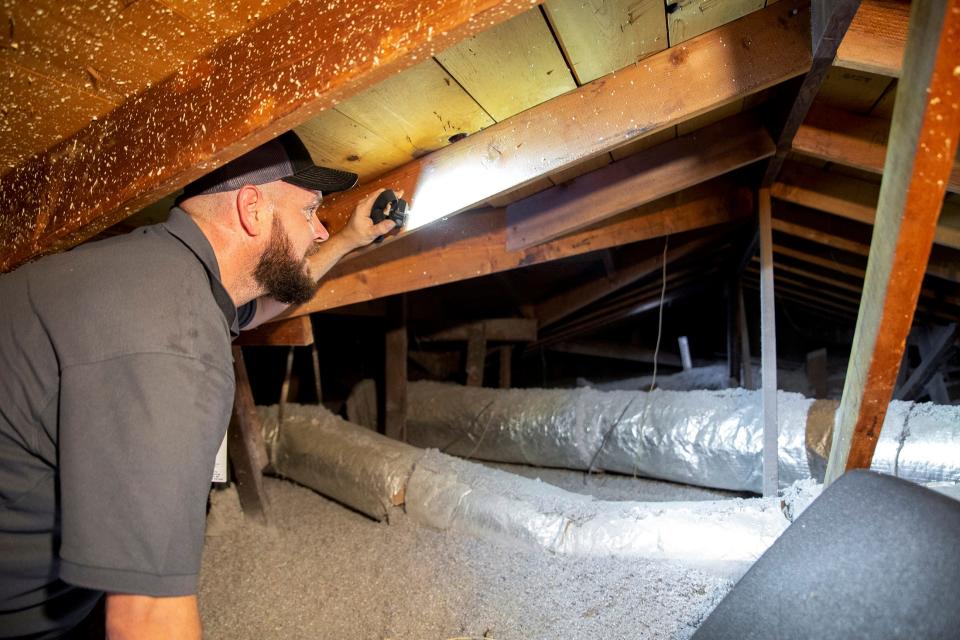 Attic insulation is checked as part of an Oklahoma Gas and Electric weatherization upgrade on a customer's home.