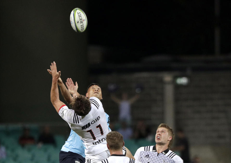 Crusaders' George Bridge, left, and Waratahs' Israel Folau, second left, compete for a high ball during their Super Rugby game in Sydney, Australia, Saturday, March 23, 2019. (AP Photo/Rick Rycroft)