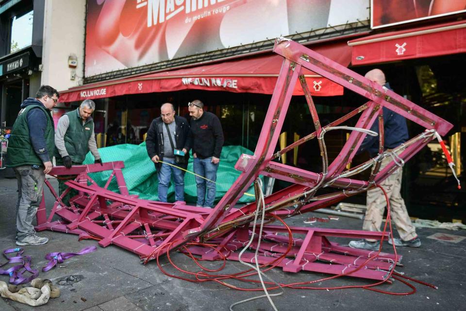 <p>Abdullah Firas/ABACA/Shutterstock </p> Workers remove the wings of the Moulin Rouge cabaret in Paris on April 25.
