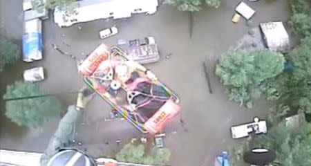 An aircrew from Coast Guard Air Station New Orleans rescues three people from a rooftop due to flooding in Baton Rouge, Louisiana, U.S., in this still image from video taken on August 13, 2016. Coast Guard Air Station New Orleans/Handout