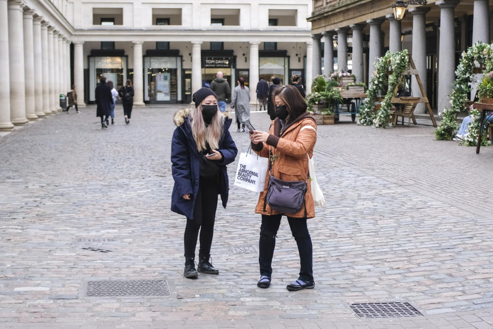Two women wear face masks in an empty Covent Garden, in London, Friday, March 13, 2020. For most people, the new coronavirus causes only mild or moderate symptoms, such as fever and cough. For some, especially older adults and people with existing health problems, it can cause more severe illness, including pneumonia.(AP Photo/Alberto Pezzali)