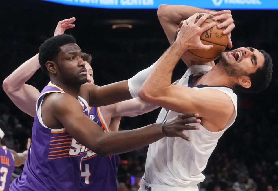 Phoenix Suns forward Chimezie Metu (4) fouls Memphis Grizzlies forward Santi Aldama (7) at the Footprint Center in Phoenix on Jan. 7, 2024.