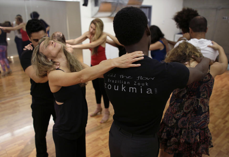 In this Monday, April 21, 2014 photo, Carmen Marshall, 42, of Miami, second from left, closes her eyes while dancers massage each other during a Brazilian zouk dance class at the VK Dance Studio in North Miami Beach, Fla. Zouk dance and music, born in the French Caribbean, adopted in Brazil and spread through Latin America and Europe, is now taking root in the United States.(AP Photo/Lynne Sladky)