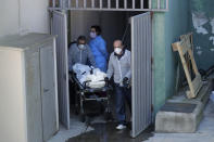 Funeral home workers carry a dead body from the Vitalia nursing homes in Leganes, Spain, Friday, April 3, 2020. The new coronavirus causes mild or moderate symptoms for most people, but for some, especially older adults and people with existing health problems, it can cause more severe illness or death. (AP Photo/Manu Fernandez)