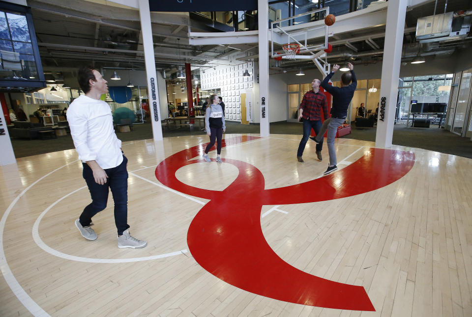 Qualtrics CEO Ryan Smith, left, plays basketball with employees at the business in Orem, Utah on Friday, Feb. 2, 2018. The majority interest of the Utah Jazz is being sold to technology entrepreneur Ryan Smith, a move that when formally approved by the NBA will end the Miller family’s 35-year run as owners of the franchise, the Jazz announced Wednesday, Oct. 28, 2020. (Jeffrey D. Allred/The Deseret News via AP)