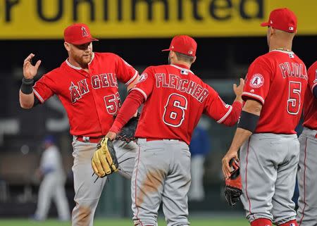 Apr 26, 2019; Kansas City, MO, USA; Los Angeles Angels right fielder Kole Calhoun (56) celebrates with teammates third basemen David Fletcher (6) and first baseman Albert Pujols (5) after beating the Kansas City Royals at Kauffman Stadium. Mandatory Credit: Peter G. Aiken/USA TODAY Sports