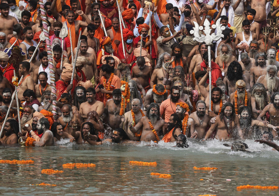 FILE - In this April 12, 2021, file photo, Hindu holy men take dips in the Ganges River during Kumbh Mela, or pitcher festival, one of the most sacred pilgrimages in Hinduism, in Haridwar, northern state of Uttarakhand, India. Despite clear signs that India was being swamped by another surge of coronavirus infections, Prime Minister Narendra Modi refused to cancel the festival, along with campaign rallies and cricket matches with spectators. The burgeoning crisis has badly dented Modi’s carefully cultivated image as an able technocrat. (AP Photo/Karma Sonam, File)