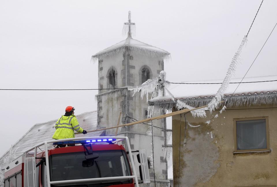 A firefighter removes ice covering electrical wiring in Pivka