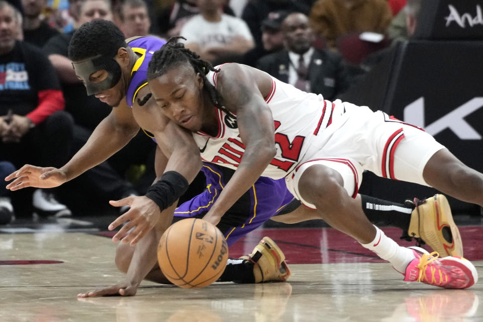 Chicago Bulls guard Ayo Dosunmu, right, battles for a loose ball against Los Angeles Lakers forward Rui Hachimura during the second half of an NBA basketball game in Chicago, Wednesday, Dec. 20, 2023. The Bulls won 124-108. (AP Photo/Nam Y. Huh)