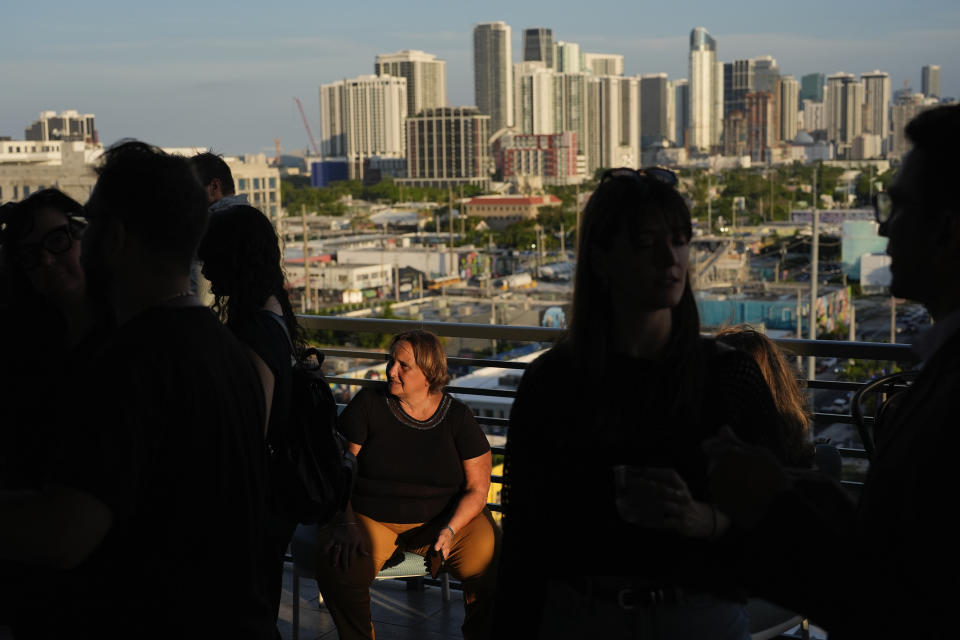 People mingle on a rooftop terrace during a pop-up tasting event for "lab-grown" meat produced by California-based Upside Foods, Thursday, June 27, 2024, in Miami. As Florida's ban on lab-grown meat is set to go into effect next week, one manufacturer hosted a tasting party, serving up cultivated chicken tostadas to dozens of attendees on a rooftop in Miami's Wynwood neighborhood. (AP Photo/Rebecca Blackwell)