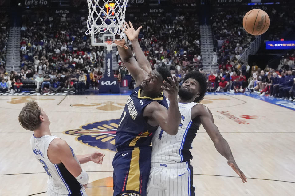 New Orleans Pelicans forward Zion Williamson (1) battles under the basket with Orlando Magic center Moritz Wagner and forward Jonathan Isaac (1) in the second half of an NBA basketball game in New Orleans, Wednesday, April 3, 2024. The Magic won 117-108. (AP Photo/Gerald Herbert)