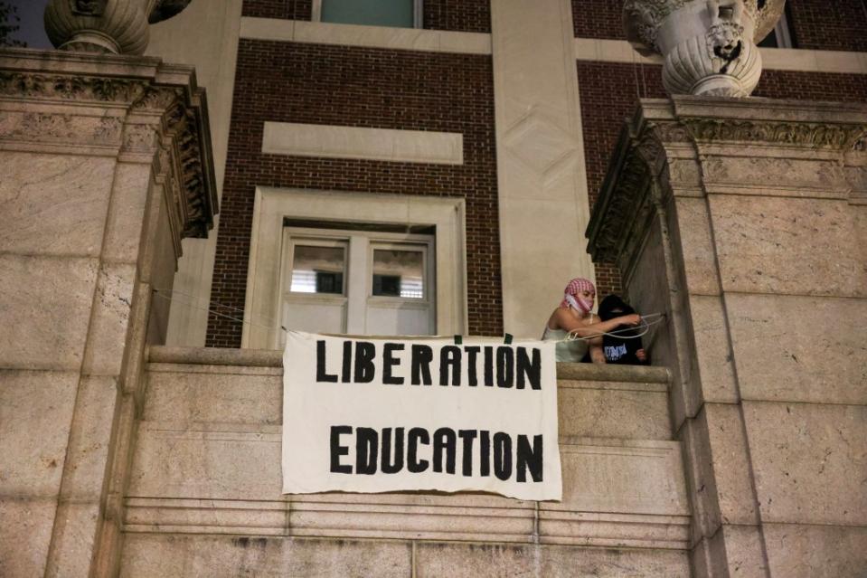 Protesters hang banners on the exterior of Hamilton Hall building after barricading themselves inside the building at Columbia University. REUTERS