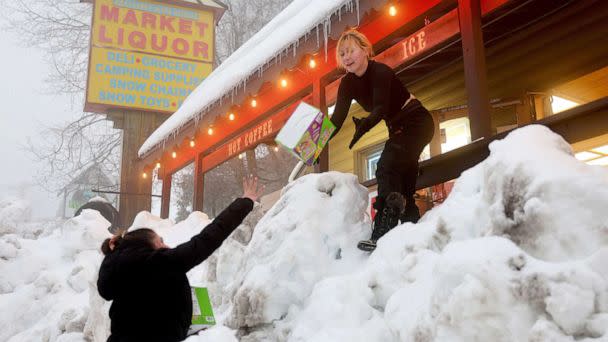 PHOTO: Resident Jessica Neakarse (R) helps Annie Ibrahim (L) re-stock Mountain High Market after a series of winter storms dropped more than 100 inches of snow in the San Bernardino Mountains in Southern California, on March 6, 2023, in Twin Peaks, Calif. (Mario Tama/Getty Images)