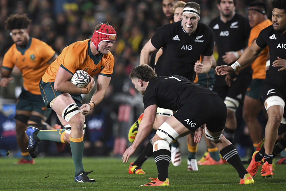 Australia's Harry Wilson, second left, charges at New Zealand's Dalton Papalii during their Bledisloe Cup rugby union test match at Eden Park in Auckland, New Zealand, Saturday, Aug. 7, 2021. (Jeremy Ward/Photosport via AP)