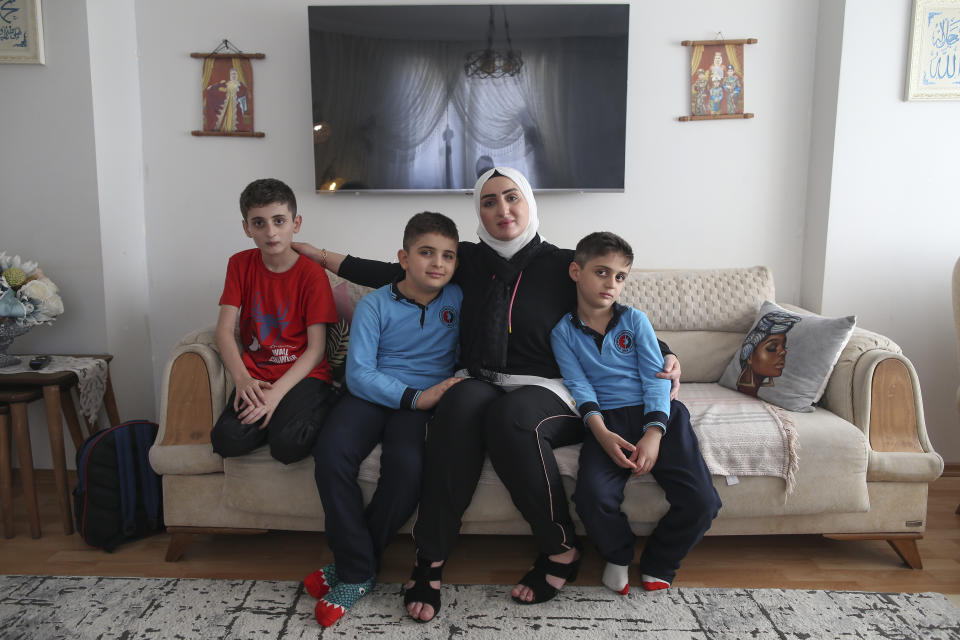 Fatima Alzahra Shon, 32, a Syrian refugee, poses with her children after an interview with The Associated Press in Istanbul, Friday, Sept. 17, 2021. Shon thinks neighbors attacked her and her son Amr, second left, in their Istanbul apartment building because she is Syrian. The 32-year-old refugee from Aleppo was confronted on Sept. 1 by a Turkish woman who asked her what she was doing in "our" country. Shon replied, "Who are you to say that to me?" The situation quickly escalated. (AP Photo/Emrah Gurel)