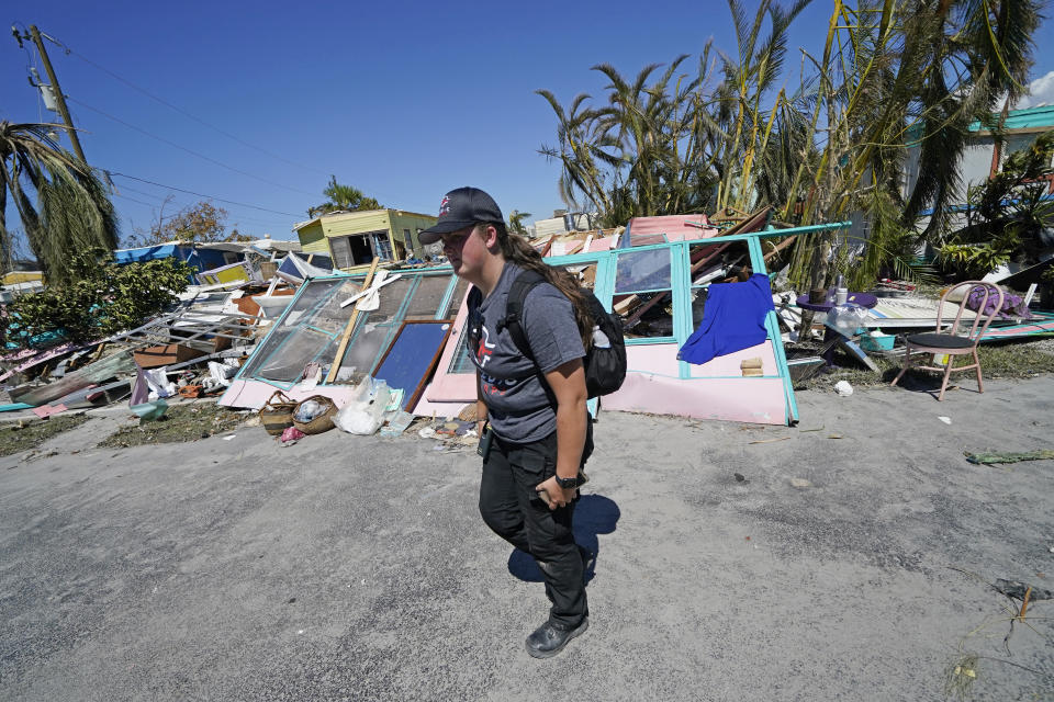 Alia Kerr, a member of mediccorps.org, which arrived on Pine Island, Fla., with two helicopters, paramedics and volunteers, searches for residents who want to evacuate in the aftermath of Hurricane Ian, Saturday, Oct. 1, 2022. The only bridge to the island is heavily damaged so it can only be reached by boat or air. (AP Photo/Gerald Herbert)