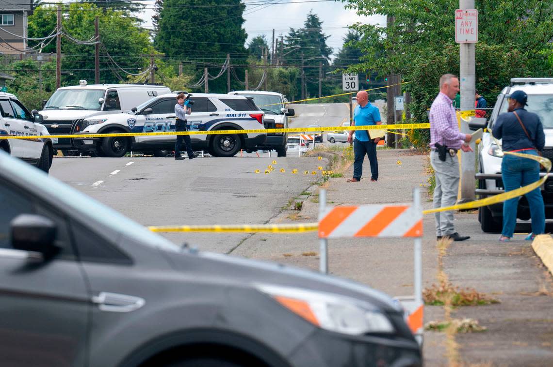 Detectives and crime-scene technicians investigate the scene of a homicide near the intersection of Martin Luther King Jr. Way and South 19th Street on Wednesday, July 6, 2022, in Tacoma, Wash. The shooting left a 14-year-old girl dead.