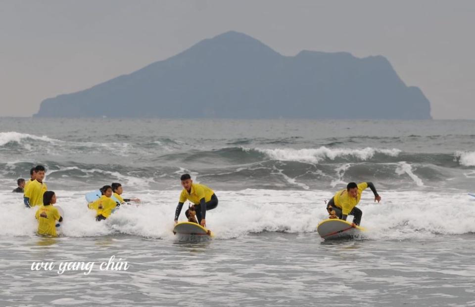 慶天宮烏面天公在頭城外海龜山島海域入海衝浪。（慶天宮提供）