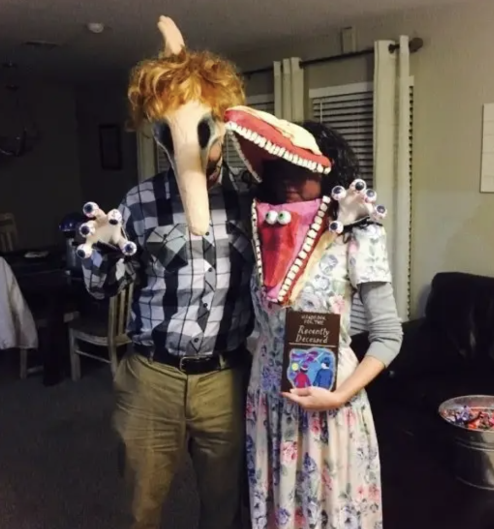 Two people dressed as the monster parents from "Beetlejuice"