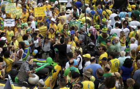 A demonstrator wearing a mask depicting Brazil's President Dilma Rousseff waves to people as they attend a protest against Rousseff, part of nationwide protests calling for her impeachment, at Copacabana beach in Rio de Janeiro, Brazil, March 13, 2016. REUTERS/Ricardo Moraes