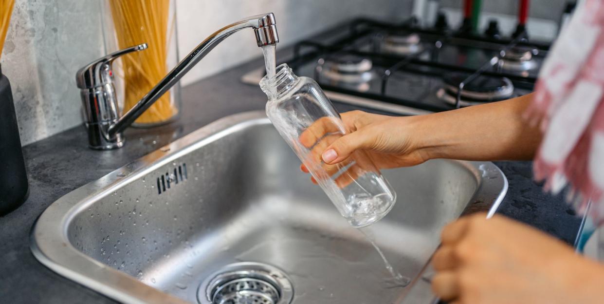 young woman filling a bottle of water