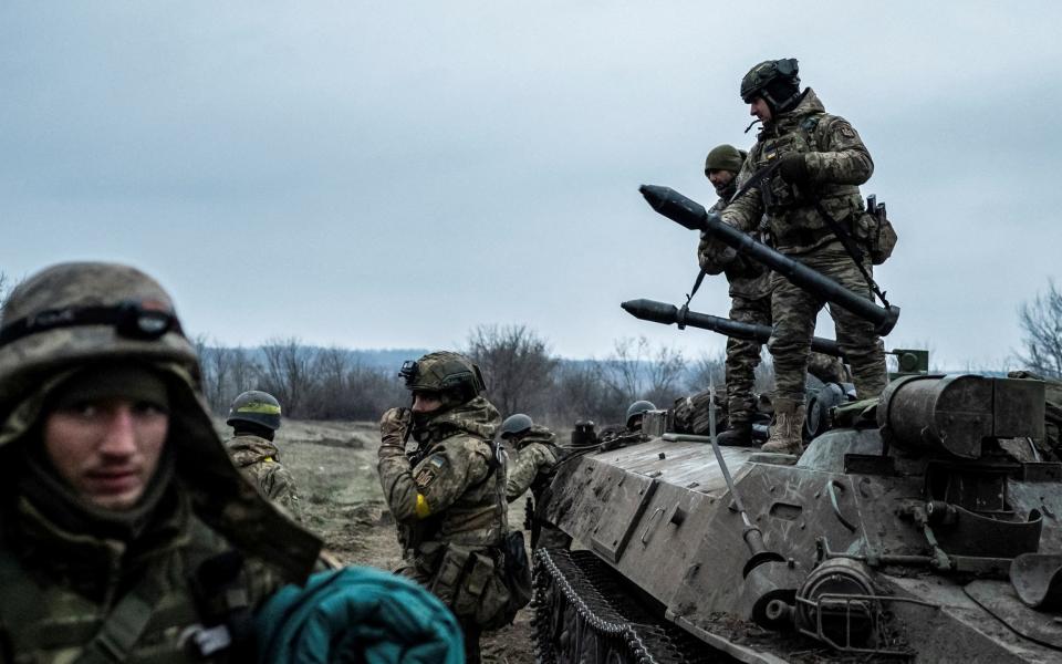 Servicemen of the Carpathian Sich Battalion are seen near an Armoured Personnel Carrier (APC) on a frontline - REUTERS/Viacheslav Ratynskyi