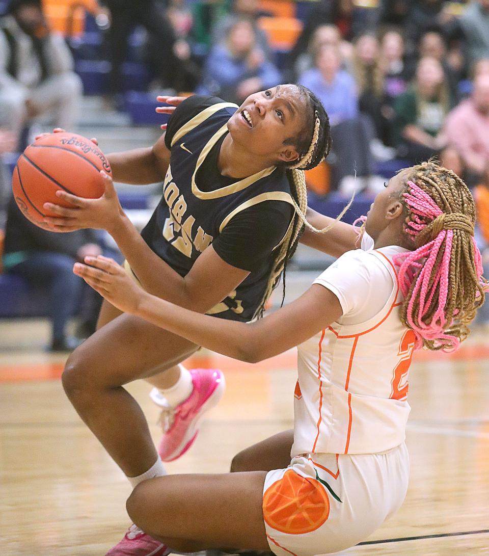 Hoban's Niera Stevens gets off a shot in the paint while being fouled by Ellet's Dacai Singletary on Dec. 13 in Akron.