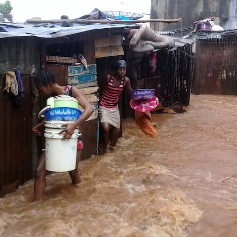 Youngsters flee flooded homes in Regent, near Freetown - Credit: Society for Climate Change Communication Sierra Leone/AFP