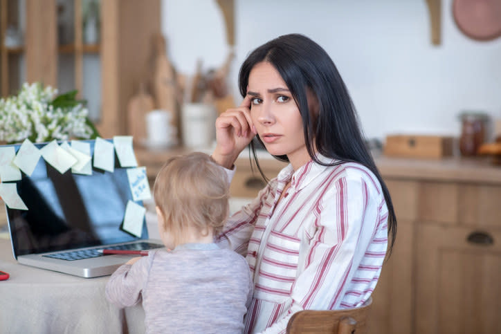 woman looking at camera confused and annoyed with kid