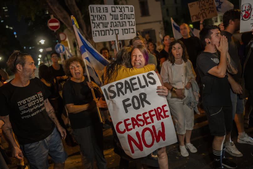 An Israeli woman calling for a cease-fire in the Gaza Strip is comforted by another protester after an argument with a right-wing Israeli in Tel Aviv, Israel, Saturday, Nov. 4