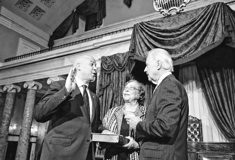 As his mother, Carolyn, holds the Bible, Cory Booker repeats the oath of office during a ceremonial swearing-in with Vice President Joe Biden on Thursday, Oct. 31, 2013.