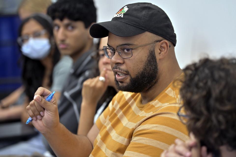 Trace Allen, an MBA student at the Sloan School of Management at the Massachusetts Institute of Technology, center, speaks during a course concerning the conflicts that arise in the siting process of renewable energy projects. at MIT, Friday, Sept. 15, 2023, in Cambridge, Mass. Students get academic credit and hands-on experience addressing real-world dilemmas, while the community and developer get free help resolving conflict. (AP Photo/Josh Reynolds)