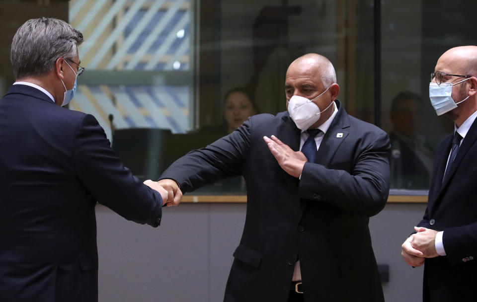 Bulgaria's Prime Minister Boyko Borissov, center, greets Croatia's Prime Minister Andrej Plenkovic, left, with a fist bump during a round table meeting at an EU summit at the European Council building in Brussels, Thursday, Oct. 15, 2020. European Union leaders are meeting in person for a two-day summit amid the worsening coronavirus pandemic to discuss topics ranging from Brexit to climate and relations with Africa. (Yves Herman, Pool via AP)