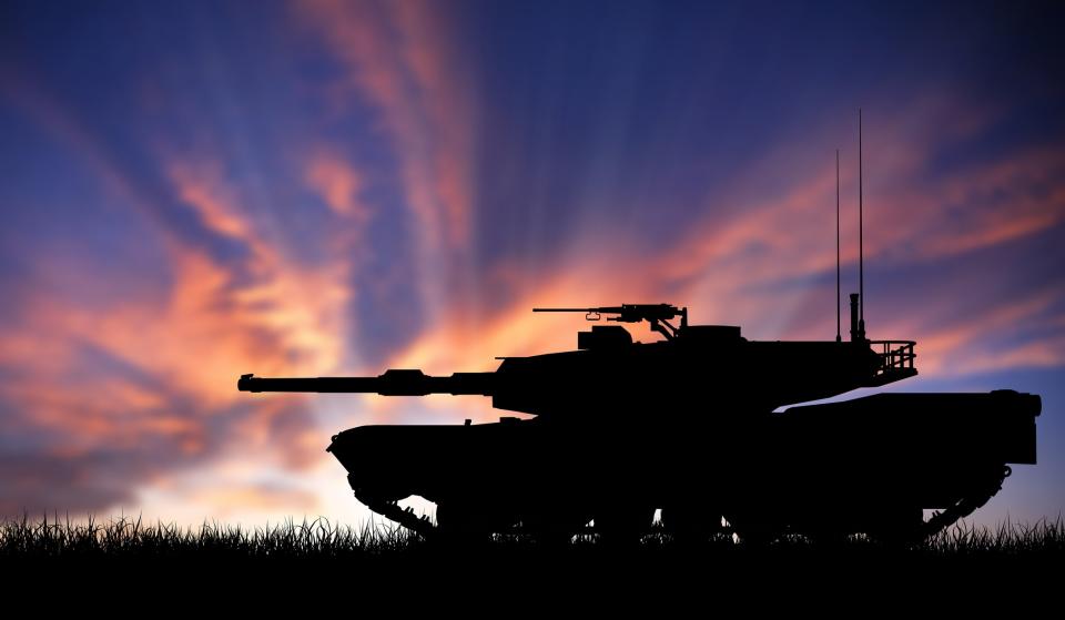 A tank silhouetted against a sunset.