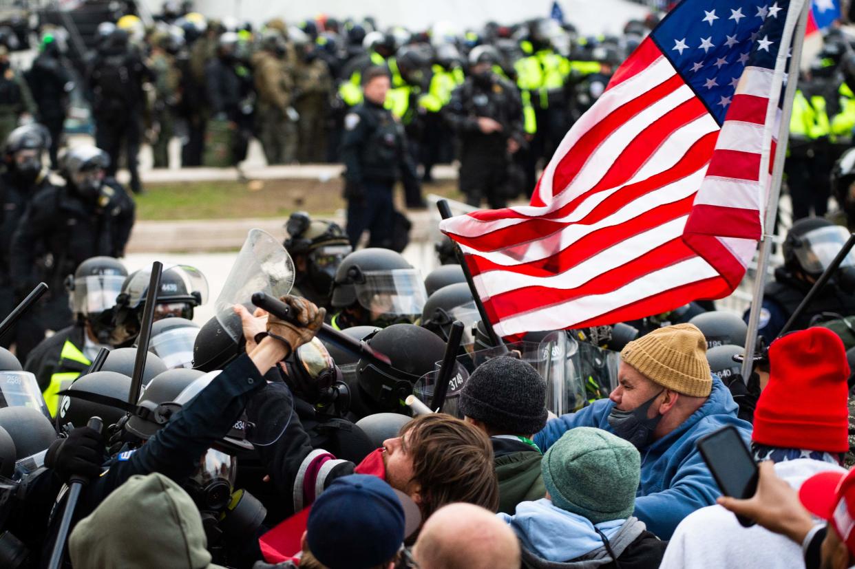 <p>Supporters of Donald Trump fight with riot police outside the Capitol building on January 6</p> (AFP via Getty Images)