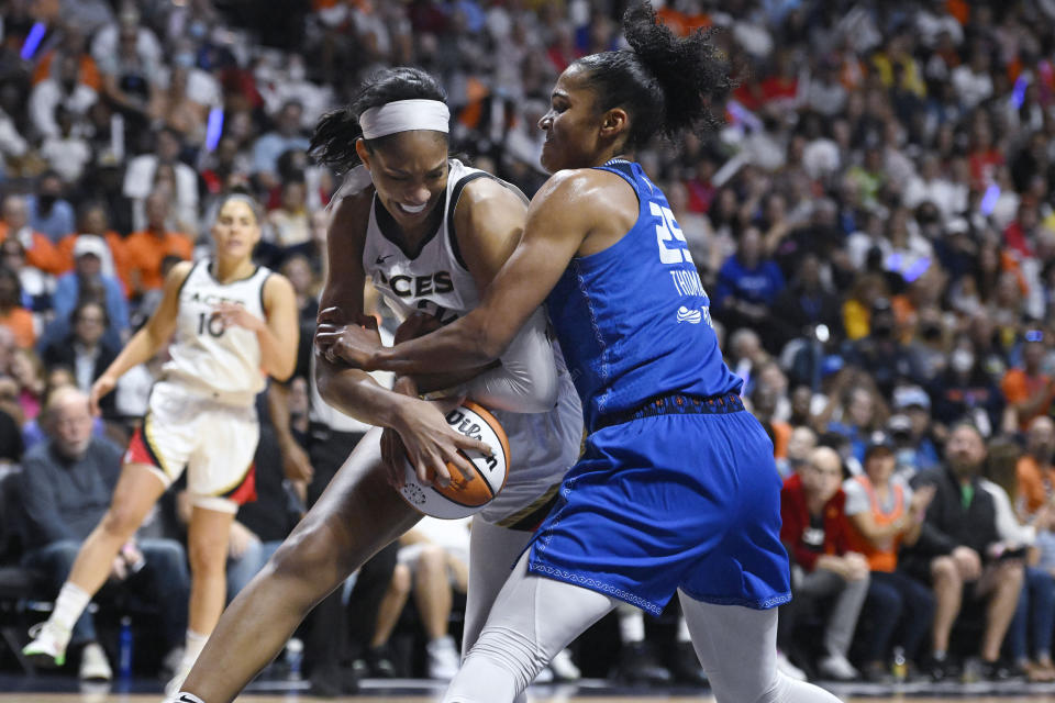 Las Vegas Aces' A'ja Wilson, left, is pressured by Connecticut Sun's Alyssa Thomas, right, during the first half in Game 4 of a WNBA basketball final playoff series, Sunday, Sept. 18, 2022, in Uncasville, Conn. (AP Photo/Jessica Hill)