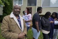 Sophonie Bizimana, left, a permanent U.S. resident who is a refugee from Congo, stands in front of his home in Kirkland, Wash., Wednesday, Oct. 14, 2020, as some of his children look at photos on their phones. Bizimana's wife, Ziporah Nyirahimbya, is in Uganda and has been unable so far to join him in the U.S. For decades, America admitted more refugees annually than all other countries combined, but that reputation has eroded during Donald Trump's presidency as he cut the number of refugees allowed in by more than 80 percent. (AP Photo/Ted S. Warren)