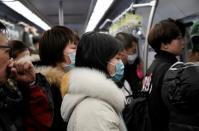 People wearing masks are pictured on the subway in Beijing