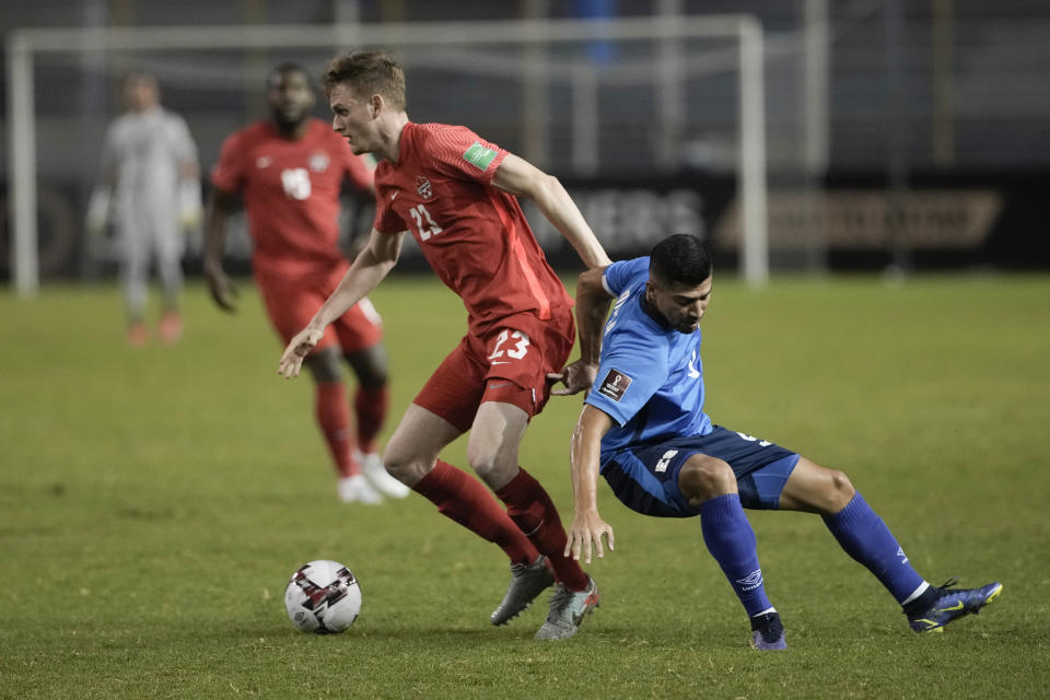 ARCHIVO - Scott Kennedy, de Canadá, izquierda, y Nelson Bonilla, de El Salvador, compiten por el balón durante partido eliminatorio a la Copa del Mundo de Qatar 2022 en el estadio Cuscatlán, en San Salvador, El Salvador, el miércoles 2 de febrero de 2022. El defensa canadiense Scott Kennedy se perderá el Mundial después de sufrir una lesión en el hombro. El seleccionado canadiense de 25 años se lesionó el sábado 29 de octubre jugando para Regensburg en contra de Rostock en la segunda división alemana. (AP Foto/Moises Castillo, Archivo)