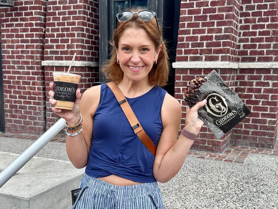 terri posing with a gideon's cookie and coffee at Disney Springs