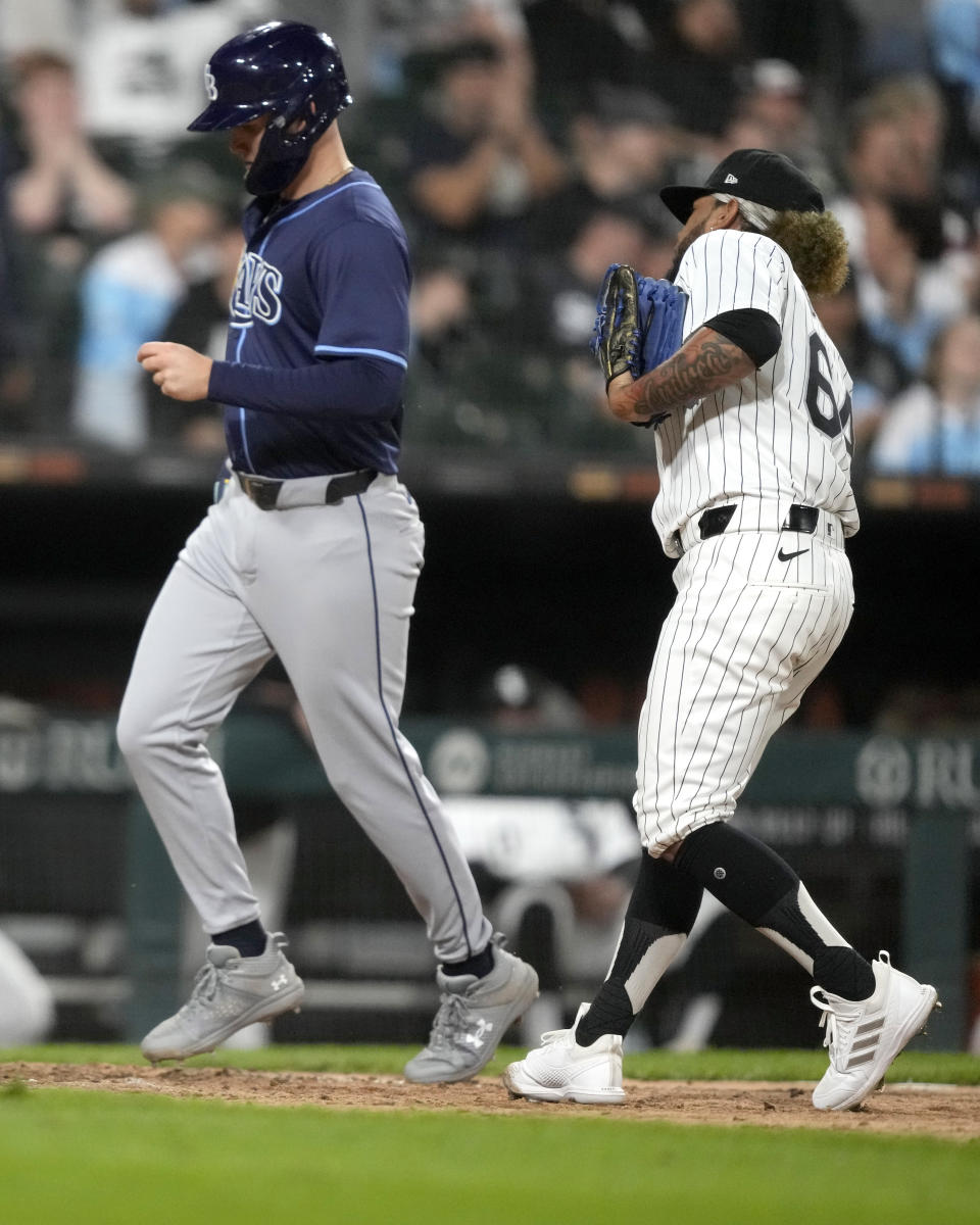 Tampa Bay Rays' Curtis Mead, left, scores past Chicago White Sox pitcher Deivi García, right, off a wild pitch by García during the 10th inning of a baseball game Saturday, April 27, 2024, in Chicago. (AP Photo/Charles Rex Arbogast)