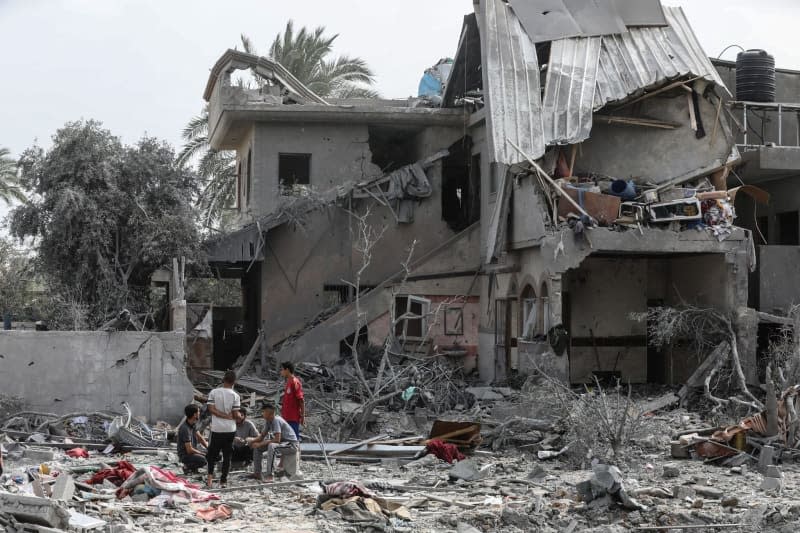 Palestinians inspect damages following an Israeli air strike on Al-Zawayda town in the central Gaza Strip. Omar Naaman/dpa